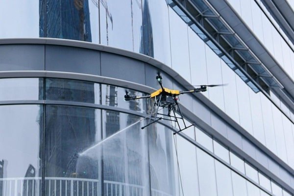 An AltitudeWash drone cleaning the glass facade of a building